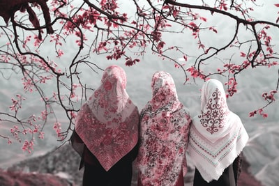Three women standing beside the tree
